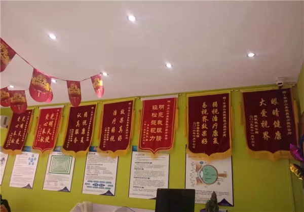易視界效果奇特家長(cháng)贈送的錦旗掛滿(mǎn)墻